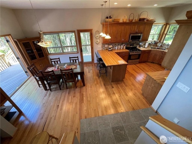 4 Ruger Rd, Oroville, WA 98844 - kitchen with stainless steel appliances, brown cabinetry, a peninsula, recessed lighting, and a kitchen bar