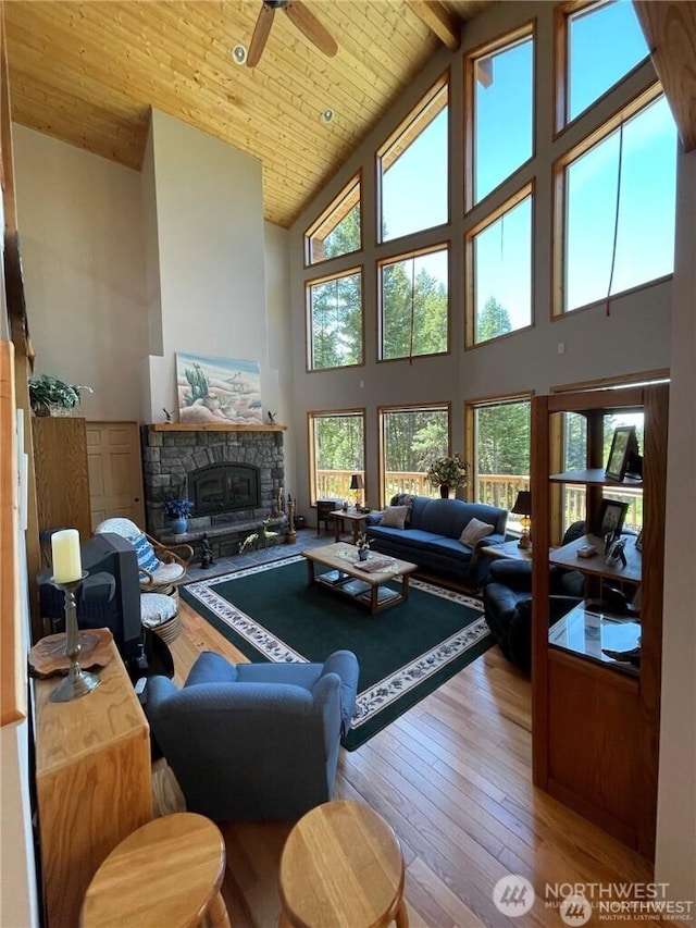4 Ruger Rd, Oroville, WA 98844 - living room with high vaulted ceiling, hardwood / wood-style flooring, a stone fireplace, a ceiling fan, and a wood ceiling with exposed beams