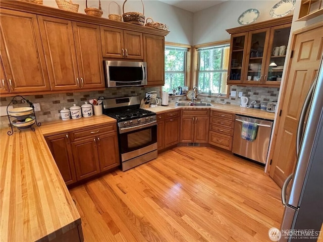 4 Ruger Rd, Oroville, WA 98844 - kitchen with appliances with stainless steel finishes, brown cabinetry, butcher block countertops, light wood finished floors, and tasteful backsplash