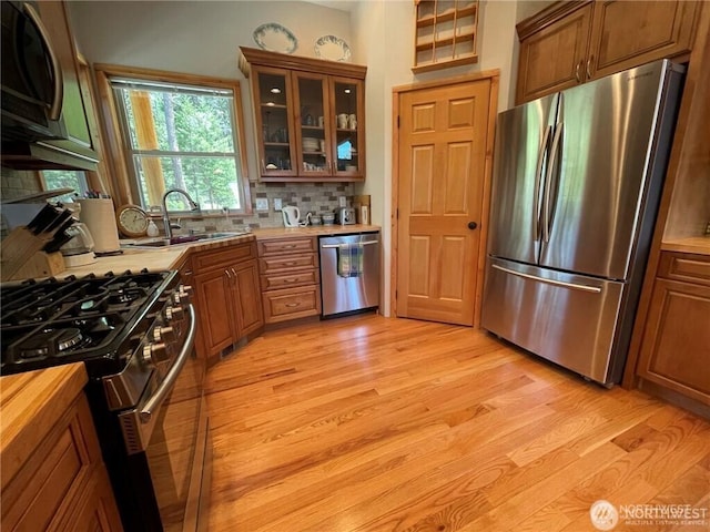 4 Ruger Rd, Oroville, WA 98844 - kitchen with appliances with stainless steel finishes, light wood-type flooring, tasteful backsplash, and brown cabinetry
