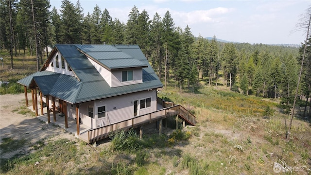 4 Ruger Rd, Oroville, WA 98844 - view of property exterior featuring a wooded view, a metal roof, and a deck