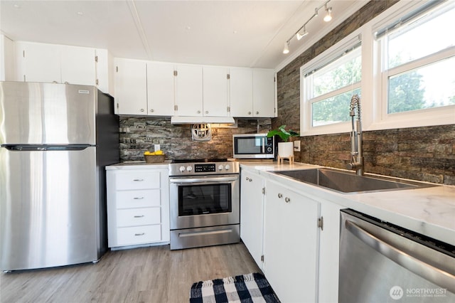 2500 Samish Way Unit 13, Bellingham, WA 98229 - kitchen with appliances with stainless steel finishes, light wood-type flooring, backsplash, and white cabinets