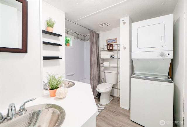 2500 Samish Way Unit 13, Bellingham, WA 98229 - bathroom with stacked washer / dryer, wood finished floors, vanity, and a shower with curtain