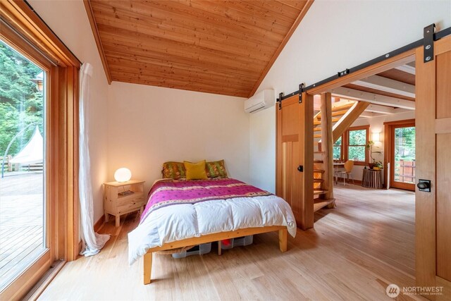 1692 Galbraith Ln, Bellingham, WA 98229 - bedroom with a barn door, vaulted ceiling, wood finished floors, multiple windows, and wooden ceiling