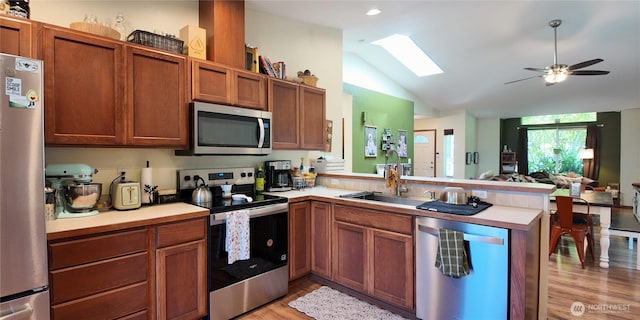 230 Goldmyer Dr, Chehalis, WA 98532 - kitchen featuring appliances with stainless steel finishes, a peninsula, a skylight, light countertops, and lofted ceiling