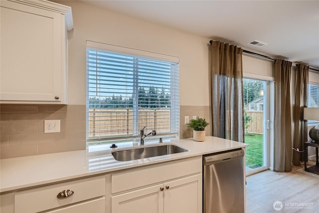 19537 141st Avenue Ct E, Graham, WA 98338 - kitchen with dishwasher, decorative backsplash, light countertops, and white cabinetry