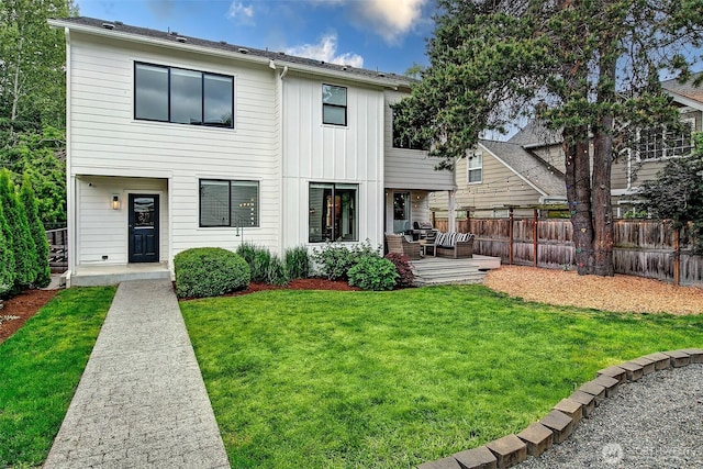 10702 39th Ave NE, Seattle, WA 98125 - rear view of property with board and batten siding, outdoor lounge area, and a patio