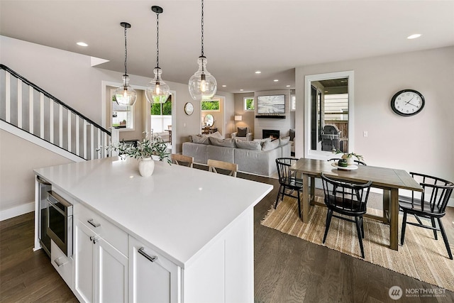 10702 39th Ave NE, Seattle, WA 98125 - kitchen featuring dark wood-style floors, white cabinets, recessed lighting, hanging light fixtures, and a center island