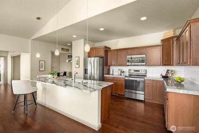 52 Carriage Dr, Sequim, WA 98382 - kitchen with stainless steel appliances, dark wood-style floors, decorative backsplash, light stone countertops, and brown cabinets