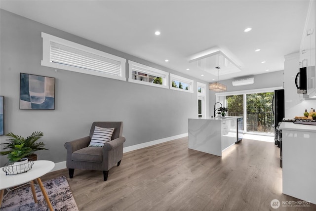 1315 Astor St, Bellingham, WA 98225 - kitchen with white cabinets, recessed lighting, light countertops, light wood-style flooring, and a kitchen island with sink