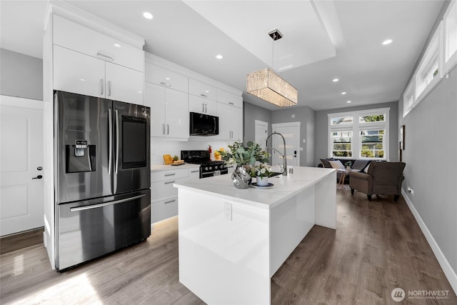 1315 Astor St, Bellingham, WA 98225 - kitchen with black appliances, white cabinets, pendant lighting, wood finished floors, and recessed lighting