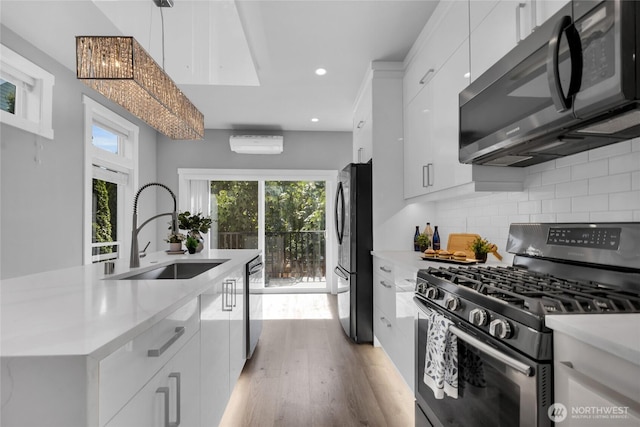 1315 Astor St, Bellingham, WA 98225 - kitchen featuring stainless steel appliances, light wood-style flooring, white cabinetry, light countertops, and backsplash