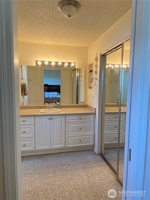 1051 Ocean Shores Blvd SW Unit 1B, Ocean Shores, WA 98569 - bathroom with vanity, a textured ceiling, and carpet flooring