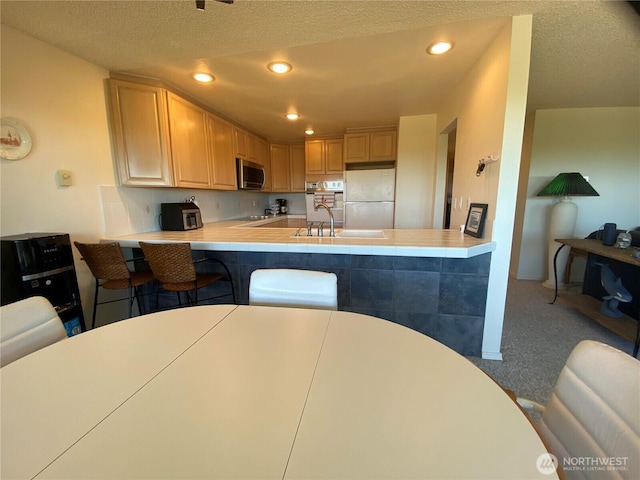 1051 Ocean Shores Blvd SW Unit 1B, Ocean Shores, WA 98569 - kitchen featuring freestanding refrigerator, carpet floors, recessed lighting, light countertops, and a peninsula