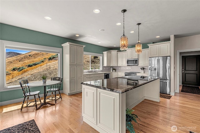 1776 Broadway Pl, Wenatchee, WA 98801 - kitchen featuring appliances with stainless steel finishes, a center island, dark stone countertops, recessed lighting, and decorative light fixtures