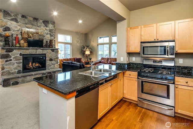 6214 Malloy Ave, Ferndale, WA 98248 - kitchen with open floor plan, a peninsula, stainless steel appliances, light brown cabinetry, and a stone fireplace