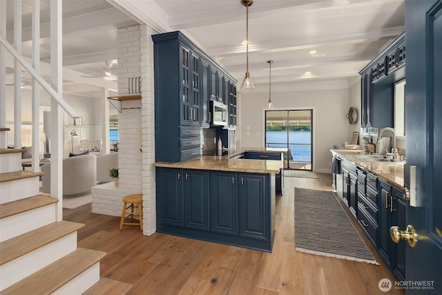26321 Pillsbury Rd SW, Vashon, WA 98070 - kitchen featuring blue cabinetry, a peninsula, light wood-type flooring, crown molding, and pendant lighting