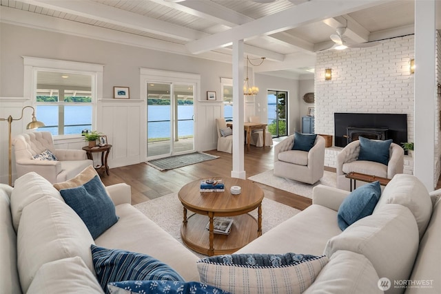 26321 Pillsbury Rd SW, Vashon, WA 98070 - living room featuring wood finished floors, a wainscoted wall, a fireplace, a decorative wall, and a wood ceiling with exposed beams