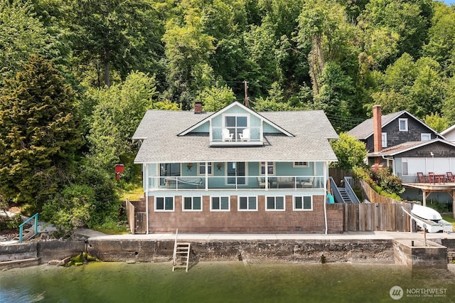 26321 Pillsbury Rd SW, Vashon, WA 98070 - back of property featuring a chimney, a balcony, a water view, and a view of trees