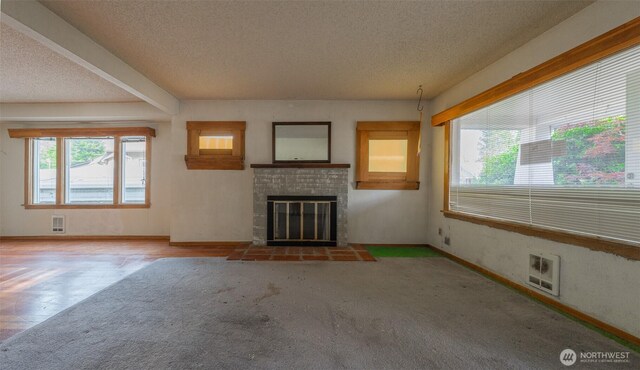 5507 N 45th St, Tacoma, WA 98407 - unfurnished living room featuring a textured ceiling, plenty of natural light, a brick fireplace, and carpet