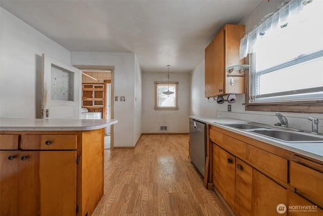 5507 N 45th St, Tacoma, WA 98407 - kitchen with brown cabinets, light wood-style floors, light countertops, and dishwasher