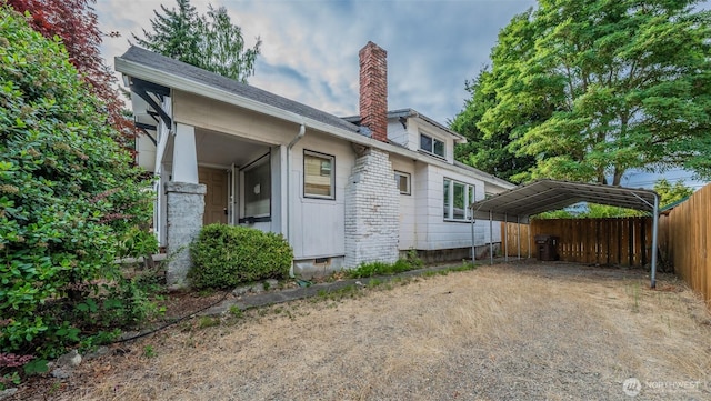 5507 N 45th St, Tacoma, WA 98407 - view of side of home with a chimney, a carport, and dirt driveway