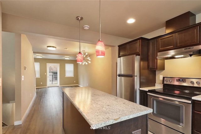 kitchen with light hardwood / wood-style floors, a center island, appliances with stainless steel finishes, hanging light fixtures, and dark brown cabinetry