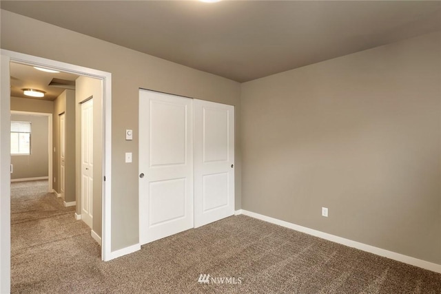 unfurnished bedroom featuring a closet and light carpet