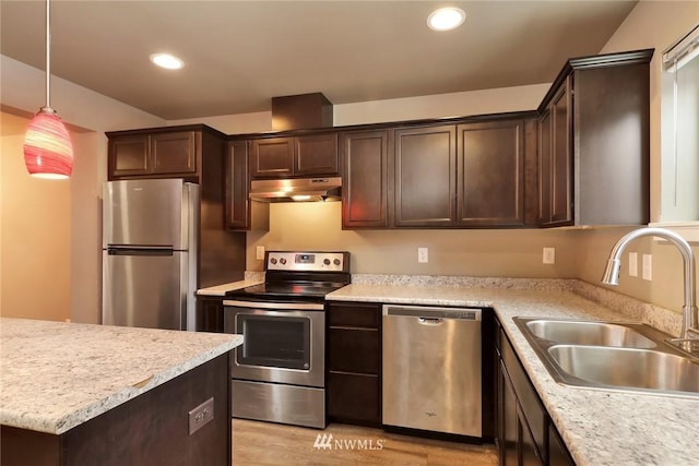 kitchen with hanging light fixtures, appliances with stainless steel finishes, light hardwood / wood-style floors, sink, and dark brown cabinetry