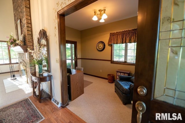 office with light carpet, brick wall, and a chandelier