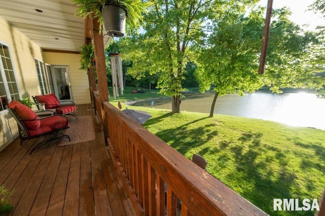 wooden terrace featuring a water view and a yard