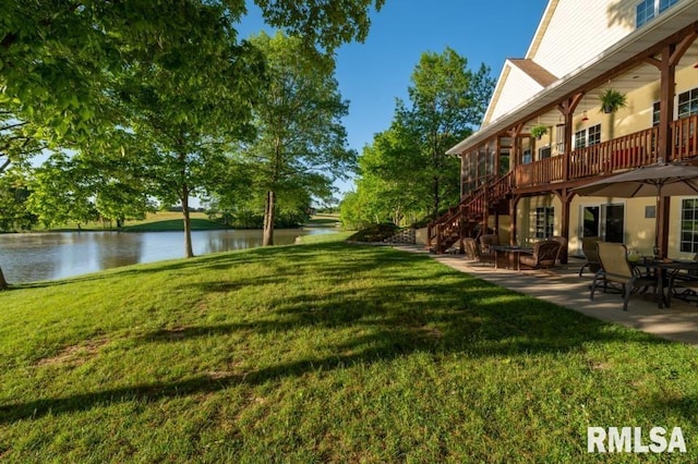 view of yard with a water view and a patio area