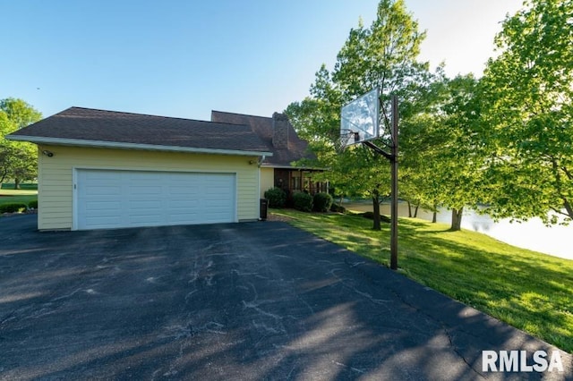 view of side of home featuring a lawn and a garage