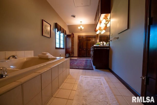 bathroom with vanity, tile floors, a chandelier, and a washtub