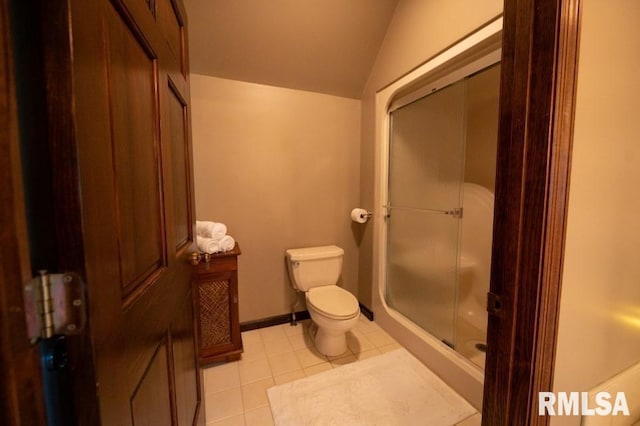 bathroom featuring lofted ceiling, tile floors, a shower with shower door, and toilet