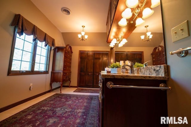 bathroom with large vanity, a chandelier, and tile floors