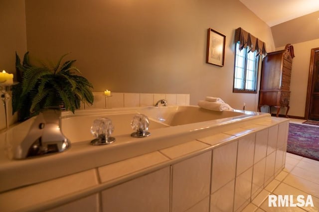 bathroom with lofted ceiling, tile flooring, and tiled tub