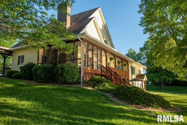 view of side of property featuring a sunroom and a lawn