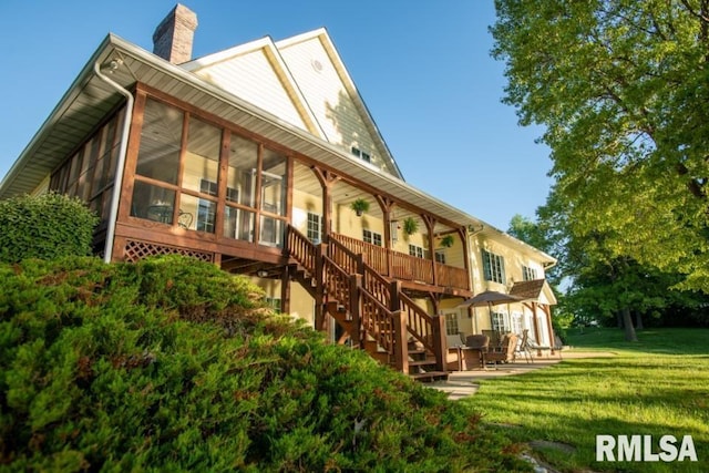 back of property featuring a lawn and a sunroom