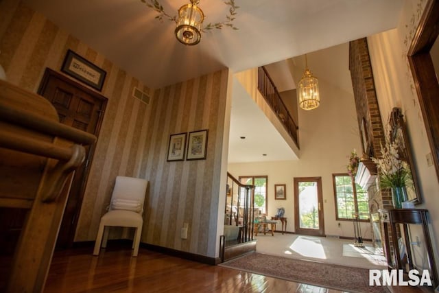 interior space with dark hardwood / wood-style flooring, a towering ceiling, and a chandelier