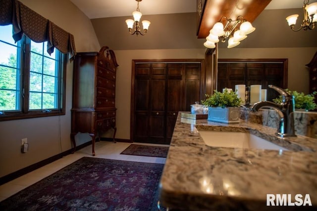 bathroom featuring tile flooring, a chandelier, and vanity