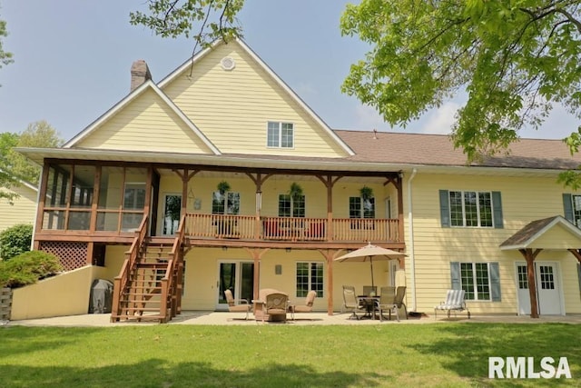 rear view of house featuring a patio and a yard