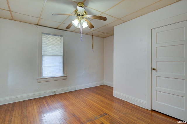 unfurnished room featuring ceiling fan, a paneled ceiling, and hardwood / wood-style floors