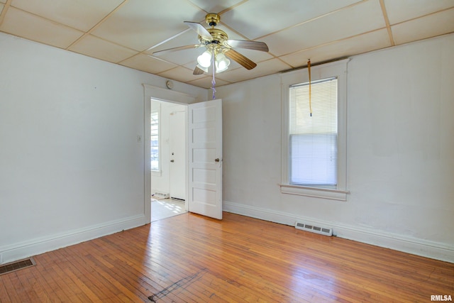 empty room featuring ceiling fan, light hardwood / wood-style flooring, and a paneled ceiling