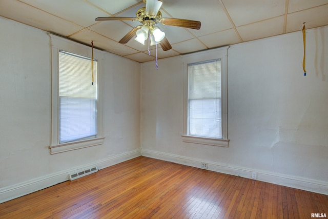 spare room featuring ceiling fan, a drop ceiling, and hardwood / wood-style floors