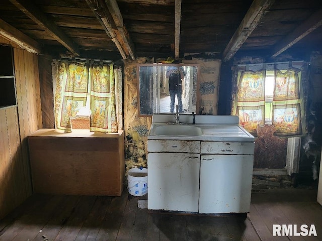 interior space with beamed ceiling, wood walls, sink, and dark hardwood / wood-style flooring