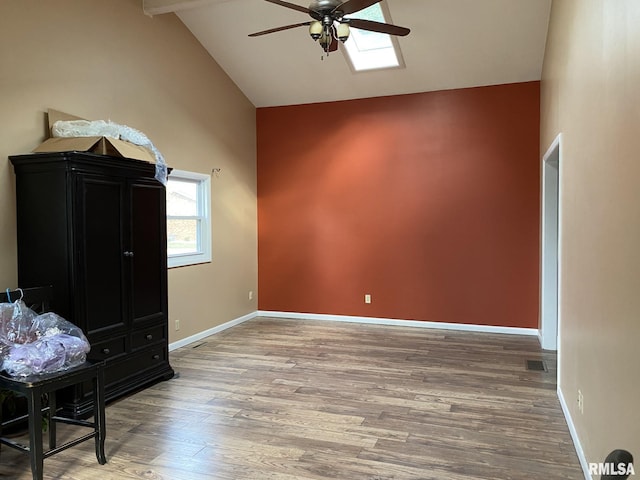 bedroom featuring ceiling fan, vaulted ceiling with skylight, and hardwood / wood-style flooring