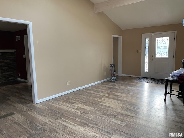 entryway with lofted ceiling with beams, a fireplace, and hardwood / wood-style floors