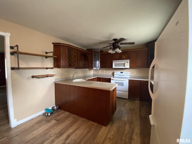 kitchen featuring kitchen peninsula, sink, white appliances, dark brown cabinetry, and dark hardwood / wood-style flooring