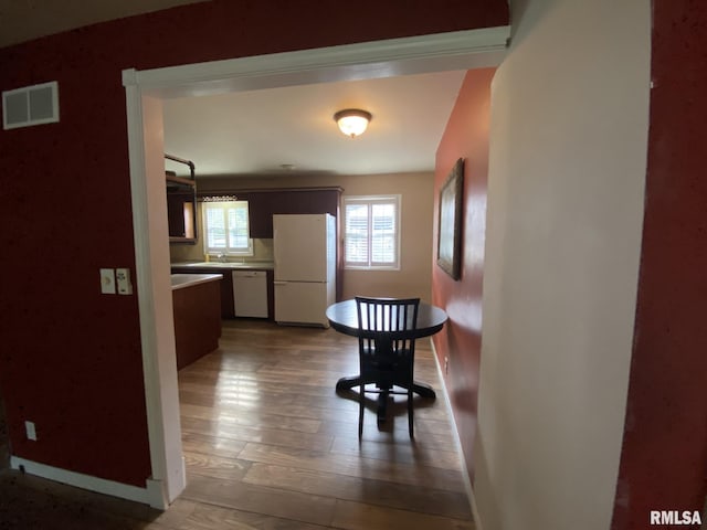 corridor with hardwood / wood-style flooring